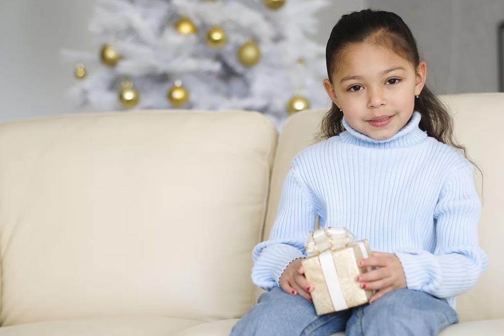 Well behaved young girl holding gift box
