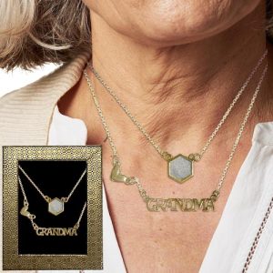 Introducing our exquisite necklace collection, perfect for your holiday fundraiser! Imagine a shimmering ensemble where gold chains elegantly drape down, one of which is adorned with a striking hexagon pendant. Another chain lovingly spells out "GRANDMA," accentuated by delightful heart-shaped links. This detailed design is captured beautifully in an inset close-up, showcasing the craftsmanship that will make this piece a cherished gift for any grandmother. Offer your supporters the chance to gift something truly unique and help raise funds this holiday season with our stunning catalog selection!.
