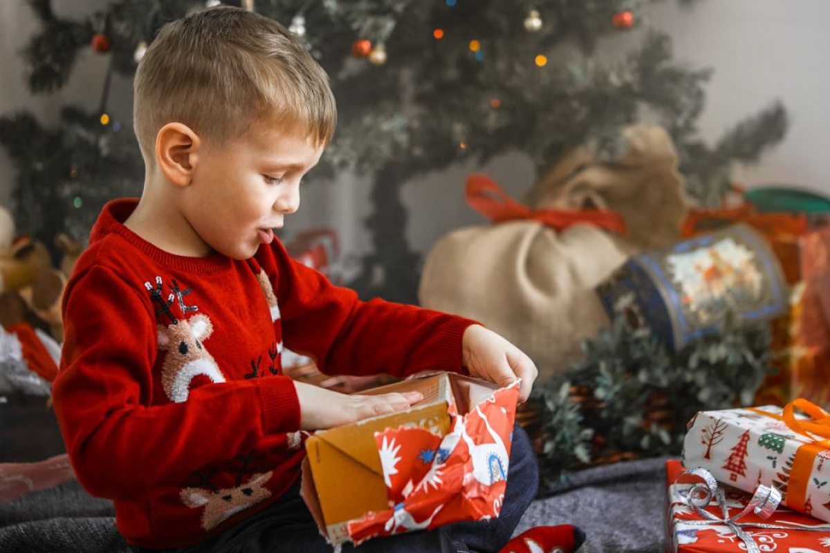 Experience the magic of giving with our holiday fundraising catalogs! Picture this: a young boy in a cheerful red sweater, eyes sparkling with excitement, opens a beautifully wrapped present while gathered with family in front of a festively decorated Christmas tree surrounded by colorful gifts. Help make moments like these possible for your school or organization—our wide selection of holiday gifts and treats ensures your fundraiser brings joy to every home this season!.